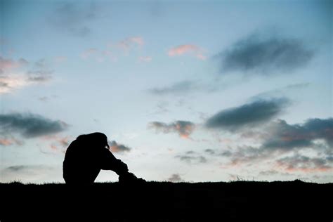 Silhouette Of Sad Woman Head On Knees At Sunset 1954155 Stock Photo At