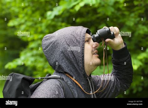 Man with binoculars watching birds in the park Stock Photo - Alamy