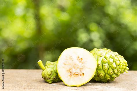 Noni fruit and noni slice on wooden table and green background.Fruit ...