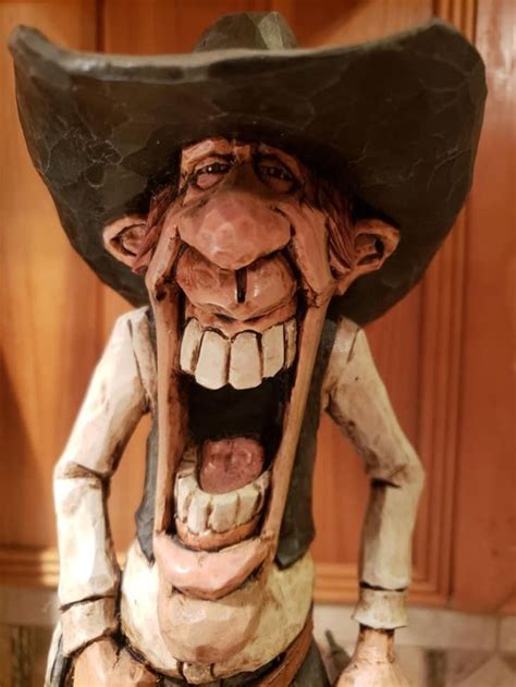 A Statue Of A Man In A Cowboy Hat With His Mouth Open And Teeth Wide Open