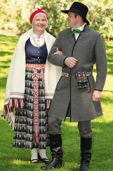 A Man And Woman Dressed In Costume Standing Next To Each Other On Green