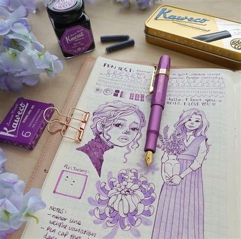 A Purple Pen Sitting On Top Of A Notebook Next To Some Flowers And