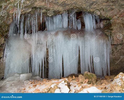 Flera Istappar Hänger Ner Från En Hylla I En Grotta Arkivfoto Bild av