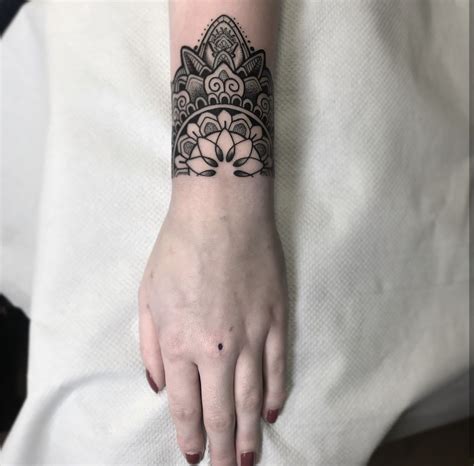 A Woman S Hand With A Black And White Tattoo Design On Her Left Wrist