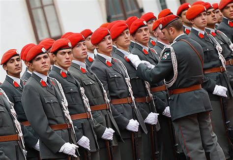 An Austrian army officer (R) adjusts the uniforms of a soldier as they ...