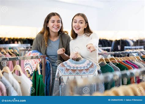 Chicas Felices Apuntando Con El Dedo A Ropa Nueva En La Tienda De Ropa