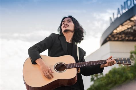 El Hombre Canta Una Canci N Y Toca La Guitarra Al Aire Libre Foto Premium