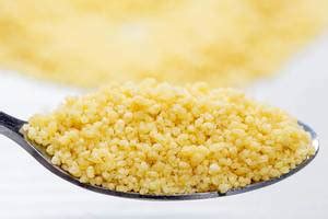 Dry Seeds Of Pardin Lentils In A Wooden Spoon And Sprinkled On A White