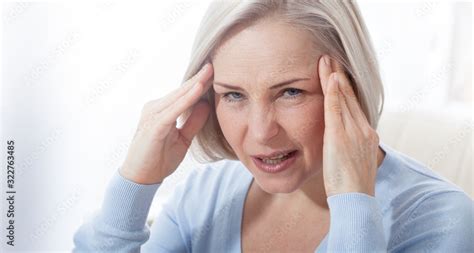 Woman Suffering From Stress Or A Headache Grimacing In Pain As She