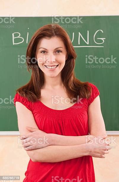 Teacher Standing In Front Of Chalkboard Arms Crossed Smiling Stock