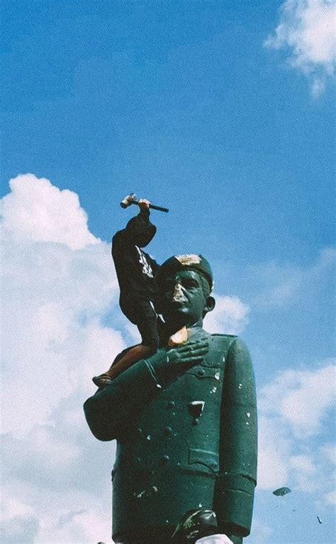 A Statue Of A Man Holding A Baseball Bat In Front Of A Cloudy Blue Sky