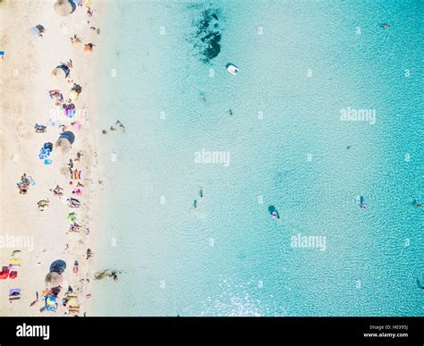 Aerial View Of Sandy Beach With Tourists Swimming In Beautiful Clear