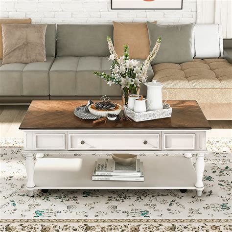 A Living Room With A Couch Coffee Table And Flowers On The Coffee Table In Front Of It