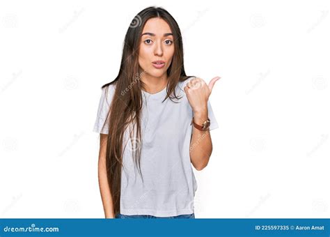 Young Hispanic Girl Wearing Casual White T Shirt Surprised Pointing With Hand Finger To The Side