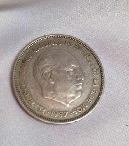 An Old Silver Coin Sitting On Top Of A White Cloth With The Image Of A