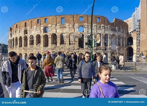 People Crossing The Road On The Crosswalk Next To The Coliseum In Rome