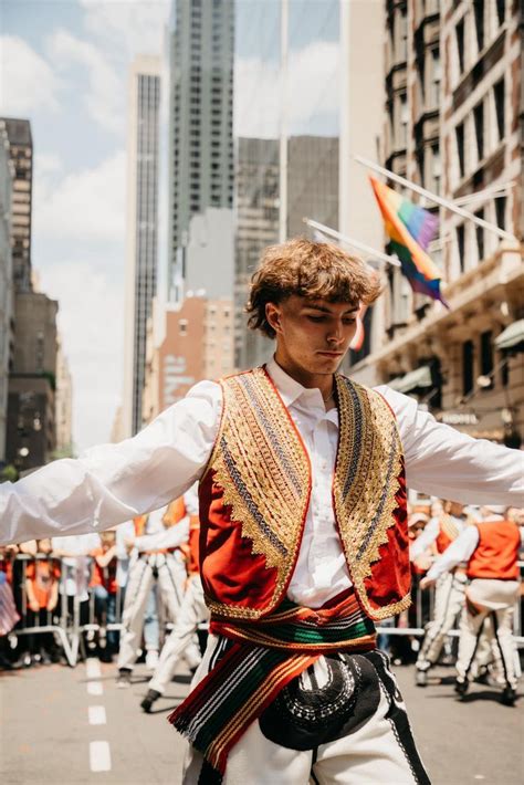 a man in an elaborately decorated vest is walking down the street with ...