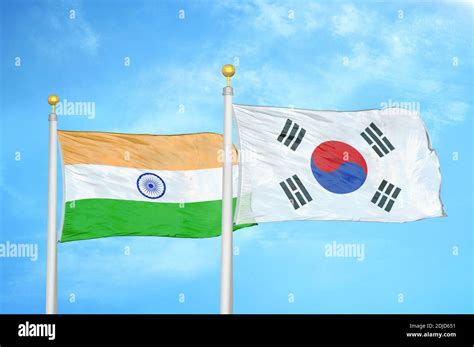 India And South Korea Two Flags On Flagpoles And Blue Cloudy Sky Stock