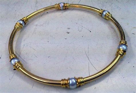 A Gold Bracelet With Blue Beads On It