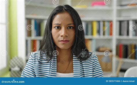 African American Woman Student Sitting On Table With Relaxed Expression