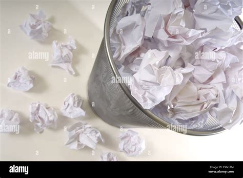 An Overflowing Waste Basket Full Of Crumpled Pieced Of Paper Stock