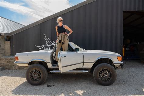 A Woman Standing On The Back Of A White Truck