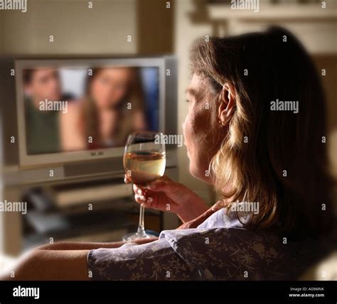 Woman watching alone tv drinking wine Stock Photo - Alamy