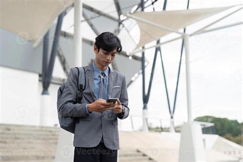 Young professional texting on smartphone outside a modern building
