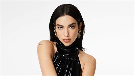 English Girl Singer Dua Lipa With Black Hair And Earrings In White