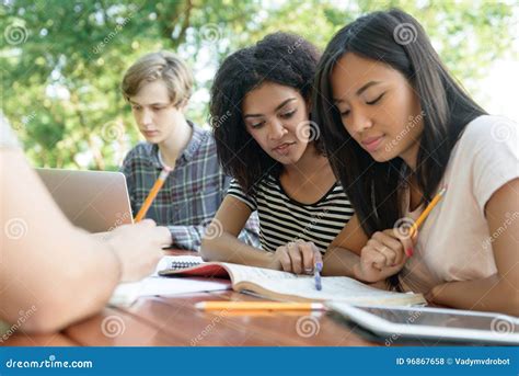 Multiethnic Group Of Young Students Sitting And Studying Stock Photo