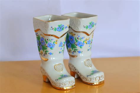 A Pair Of White Boots Sitting On Top Of A Wooden Table