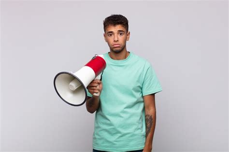 Premium Photo Young Man With A Megaphone Feeling Sad And Whiney With