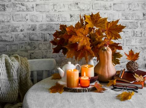 Premium Photo Lit Candles Dry Maple Leaves Pumpkin Stack Of Books