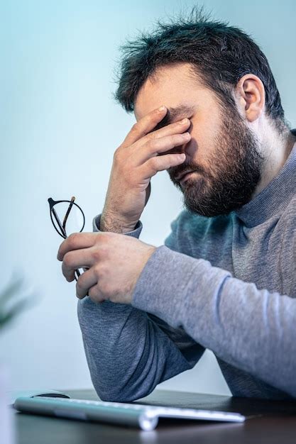 Un Hombre Cansado Se Frota Los Ojos Frente A La Pantalla De Una