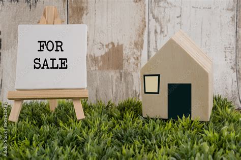 maison en bois à vendre avec un panneau sur un chevalet écrit en