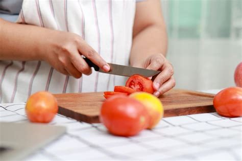 Mujer asiática gorda cocinando en la cocina y cortando verduras