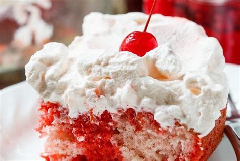 A Piece Of Red Velvet Cake With Whipped Cream And A Cherry On Top Is