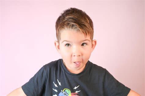 Retrato De Un Lindo Niño De 4 Años Mostrando Su Lengua Sobre Fondo Rosa Foto Premium