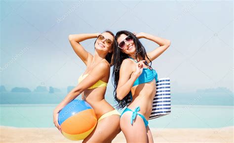 mujeres jóvenes felices en bikini posando en la playa de verano 2024