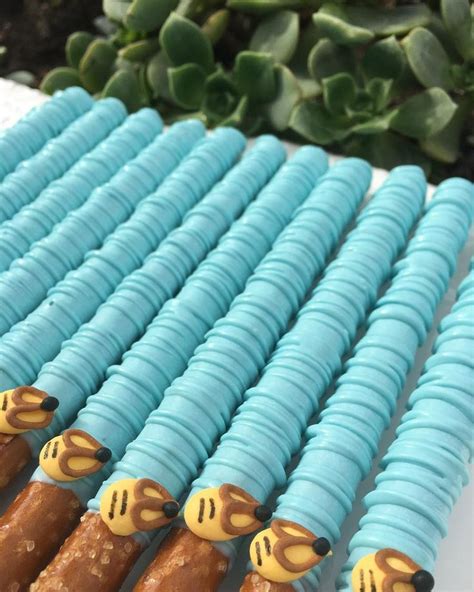 There Are Many Blue And Yellow Cake Sticks With Giraffes On Each One