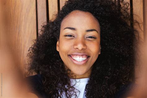 Closeup Of A Young African American Woman Taking A Selfie On A Wooden Floor By Stocksy