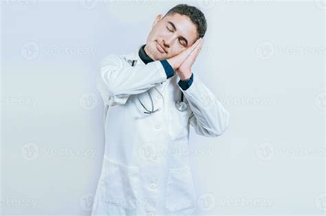 Young doctor making sleep gesture isolated. Handsome doctor making ...