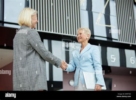 Successful Mature Businesswoman In Elegant Suit Shaking Hands To Her