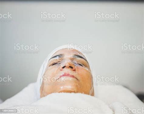 Mature Female Customer With Facial Mask Stock Photo - Download Image