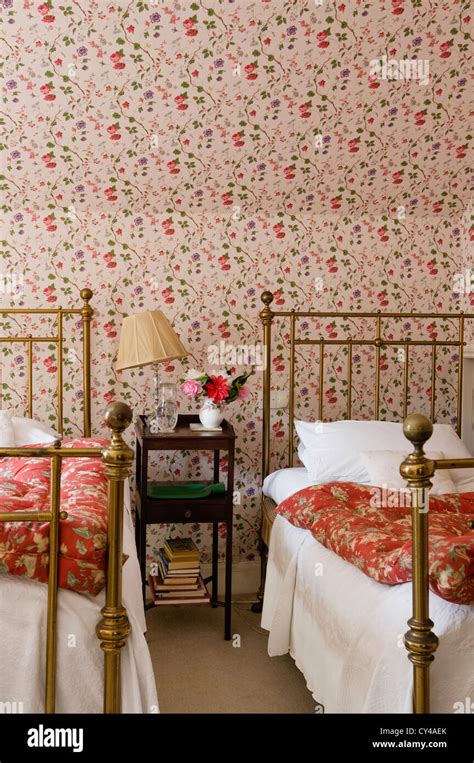 Twin Wrought Iron Beds In Bedroom With Floral Patterned Wallpaper And