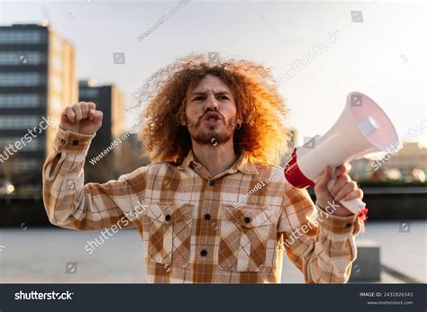 angry man shouting megaphone  sky stock photo