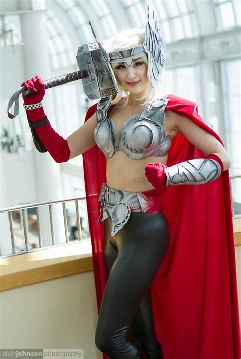 A Woman Dressed As Thor From The Avengers Movie Holding An Ax In Her