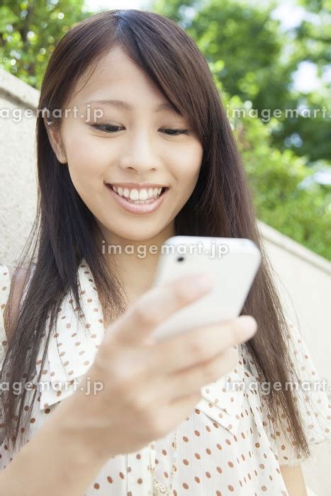 スマートフォンを操作する女性の写真素材 23983289 イメージマート