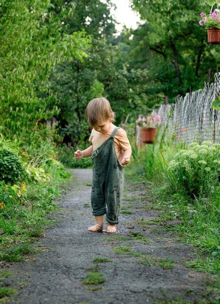 Une Petite Fille Marche Pieds Nus Sur Un Chemin Humide Photo Premium