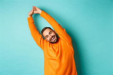 Premium Photo Smiling Man With Arms Raised Standing Against Blue